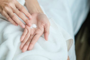 Kadın ellerine nemlendirici krem sürüyor. Güzellik konsepti..