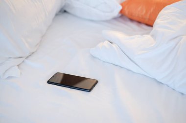 Akıllı telefon beyaz ekran dağınık yatak, akıllı telefon konsepti.