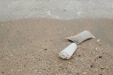 Plajda plastik torba, çevre konsepti.