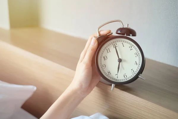 침대에서 여자는 아침에 자명종 시계를 — 스톡 사진