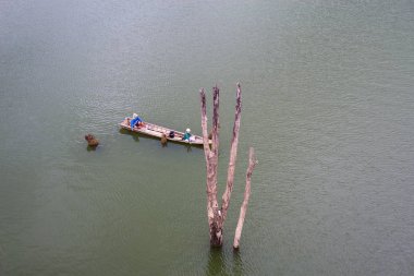 Bir balıkçı long tail tekne rides Songkhalia Nehri, Sangkhlaburi, Kanchanaburi, Tayland.