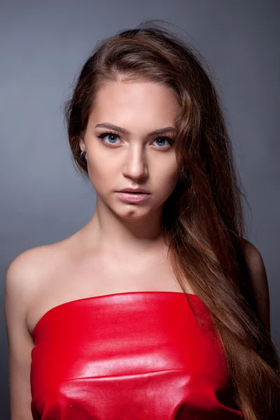 Retrato del adolescente con un vestido rojo sobre un fondo gris — Foto de Stock