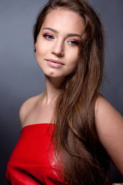 Portrét teenagera v červených šatech na šedém pozadí. — Stock fotografie