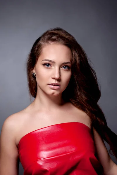 Портрет подростка в красном платье на сером фоне — стоковое фото