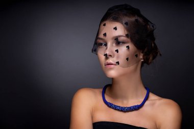 Koyu gri arka planda bir genç kızı portresi.
