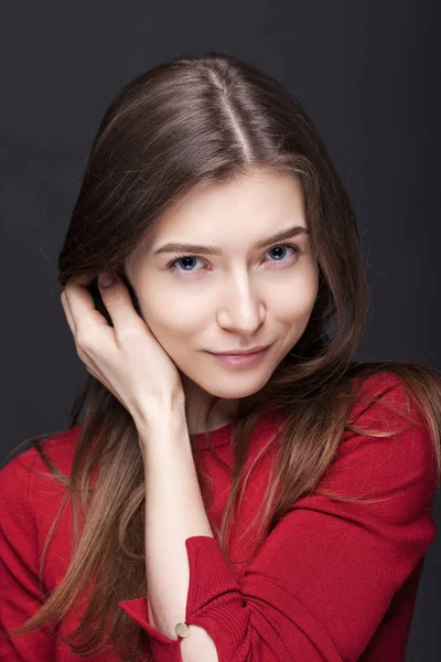 Портрет женщины на сером фоне в красном свитере — стоковое фото