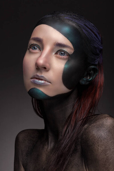 Portrait of a woman with creative make-up on a gray background. 