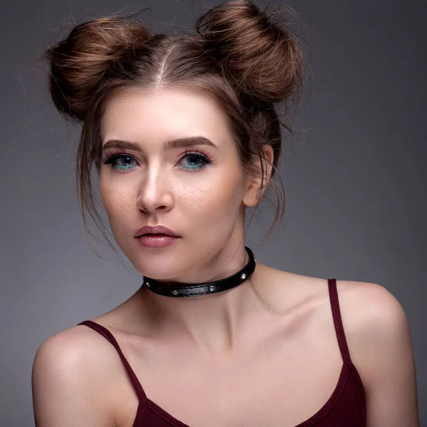 Retrato de uma menina bonita com uma bela maquiagem em um cinza — Fotografia de Stock