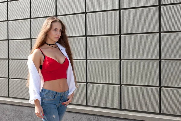 Ritratto di un'adolescente in una strada vicino a un muro grigio — Foto Stock