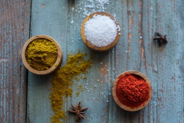 Baharat. Otlar. Köri, tuz, biber safran, zerdeçal, tandori masala ve diğer bir ahşap rustik arka plan üzerinde. Farklı baharatlar ve otlar büyük koleksiyonu.