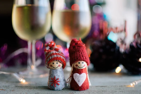 Copas de vino blanco y muñecas de punto con decoración navideña — Foto de Stock