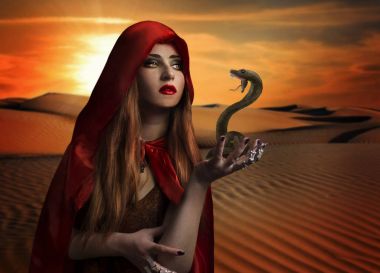 Woman with snake in the desert.  clipart
