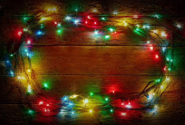 Colorful lights on rustic wooden background for christmas and new year design. Merry Christmas vintage card. Xmas lights over dark background. Old wooden table. Wood texture. Natural pattern — Stock Photo, Image