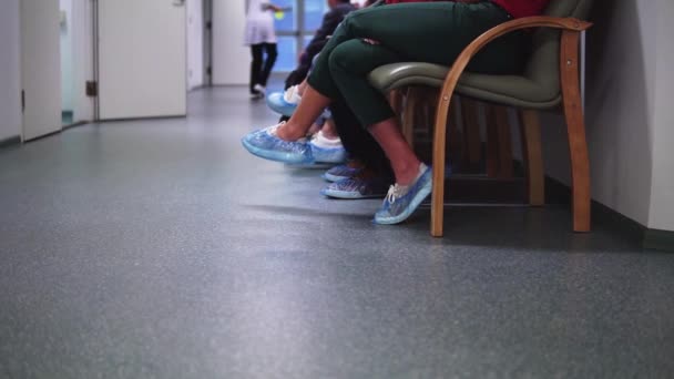 A kliensek orvosra várnak, és aggódnak, hogy egy kórházban ülnek egy cipőruhában. — Stock videók