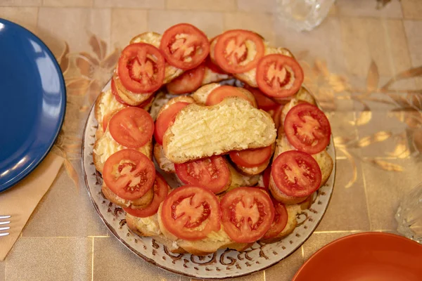 tomatoes sliced round wheels are on a sandwich of garlic