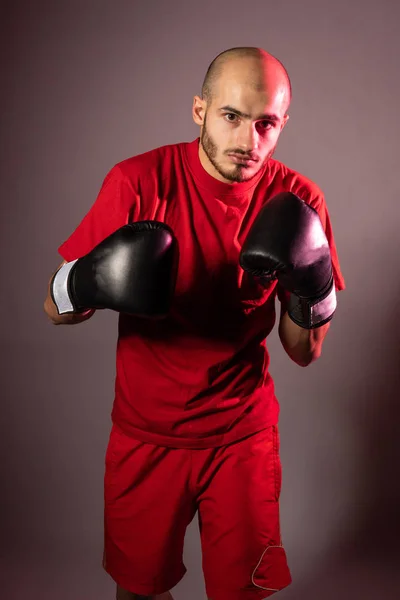 Нападение на боксера в черных перчатках и в красных шортах и футболках, подготовленных для боя — стоковое фото