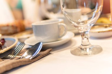 Glass white on the table glass glass and fork and spoon, white tablecloth