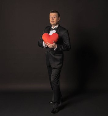 Sevgililer günü kocası, beyaz gömlekli, siyah arkaplanlı bir kalbe aşık..