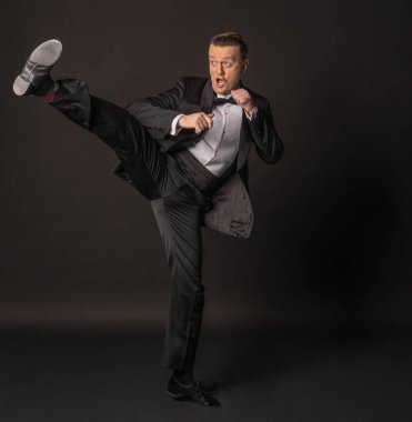 Karate 'nin siyah arka planda smokin içinde iyi bir ayağı var.