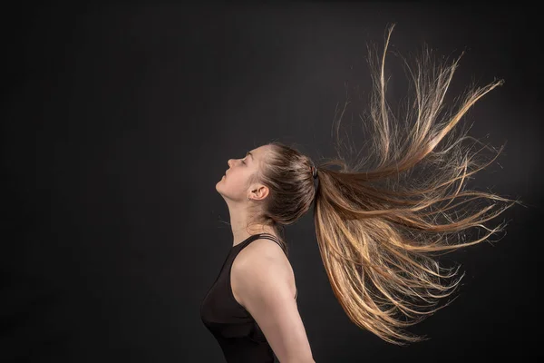 The girl in the shampoo commercial with her hair on black background — Stock Photo, Image