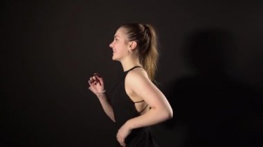 Kız sol tarafa koşuyor, siyah arka planda. kızıl saçlı, gülümseyen