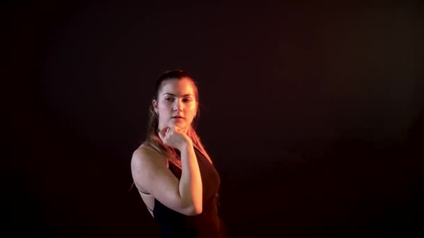 Girl snaps arm on a black background, red-haired best — Wideo stockowe