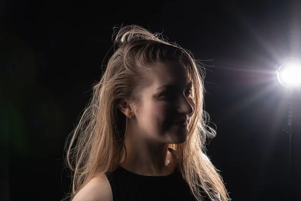 Dívka ve tmě se rozzářila paprskem světla, světlo vlasů — Stock fotografie