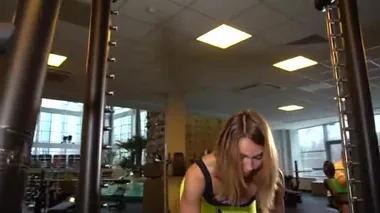 Simülatördeki yetişkin kız Smith vücut geliştirme. Çömelme, sarı kumaş.