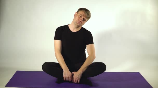 Man pulls neck and relaxes pulls vertebra in fitness — Stockvideo