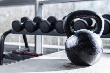 Kettlebell and dumbbell in the background black light background