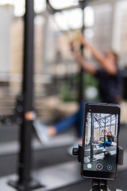 In a fitness club, a girl goes in for sports with TRX is her cross