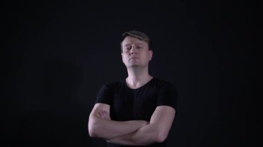 Bir adam bize yakışıklı görünüyor, kolları bağlı.