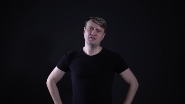 Dissatisfied man hands on waist, black background — Stock Video