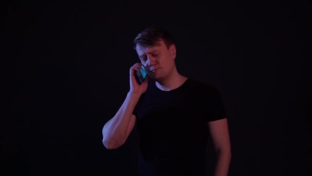 Присягає хлопця в телефоні на чорному тлі — стокове відео