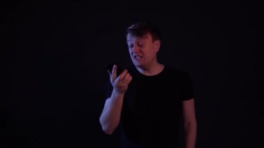 Adam telefonu Jopu 'da siyah bir arkaplanda gönderiyor.