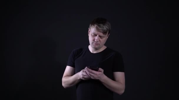 With the phone thinking the guy on the black background — Stock Video