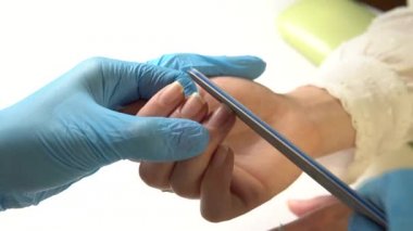 Güzellik uzmanı bir güzellik salonunda makroyla manikür yapıyor..