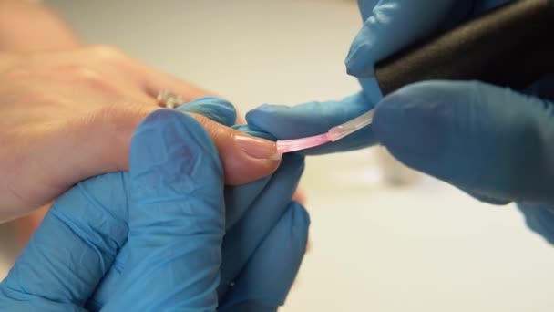 Het meisje doet de nagels met macro fotografie in de schoonheidssalon. — Stockvideo