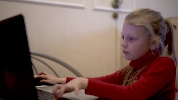 A lány a számítógépnél ül és játszik. — Stock videók