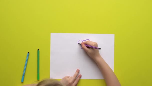 Menina mesa amarela desenha marcadores de borboleta no papel — Vídeo de Stock