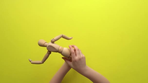 Дівчина грає на жовтому столі в ляльці з дерева — стокове відео