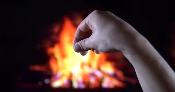 Vierte la sal de su mano hacia abajo, lentamente sobre el fondo del fuego — Vídeos de Stock