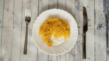 Kötü makarna sunucusu çatalı ve bıçak ahşap masa, çürük makarna, kuru