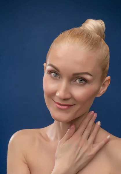 Glückliche junge Schöne lächelt in die Kamera, ein schönes weißes Gesicht Hintergrund lila mit Studiolicht. Das schöne Mädchen — Stockfoto