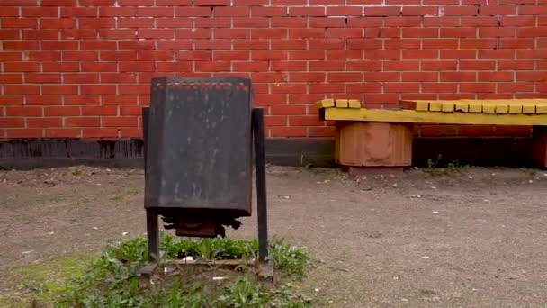 Bancs, poubelles, mur de briques en arrière-plan, caméra se déplaçant le long — Video