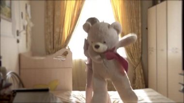 Oyuncak ayı ve kız, yatağa atlayıp neşeyle yere düşüyorlar. Kız 8 yıl Avrupa görünümü