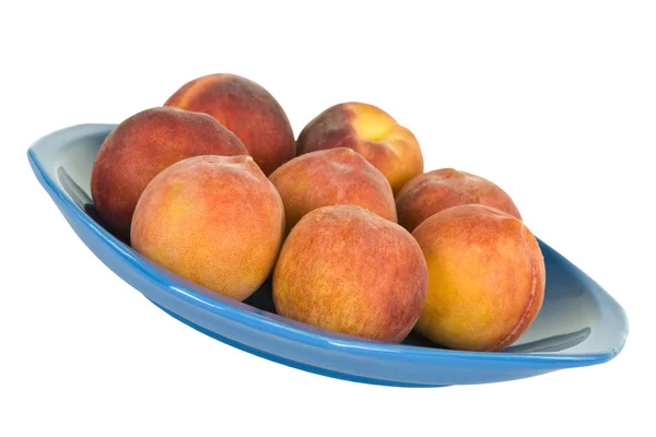 Färska persikor på blå tallrik — Stockfoto