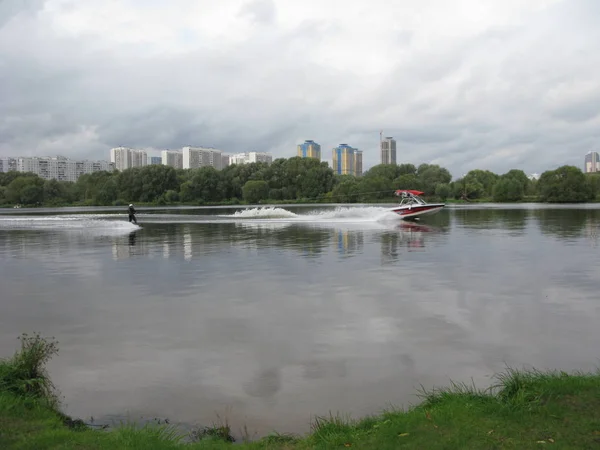 近くのモダンな高層住宅の建物と都市湖でモーター ボートと水上スキーをモスクワ 2010 — ストック写真