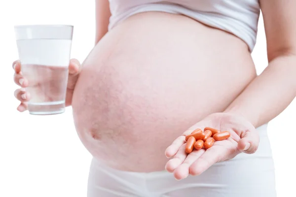 Kobieta w ciąży, biorąc leki na białym tle. — Zdjęcie stockowe