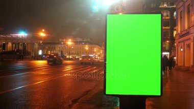 bir sokak üzerinde yeşil bir ekran ile bir Pano